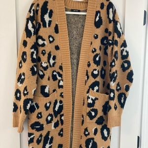 Mid-thigh length leopard print cardigan with pockets. Cozy and warm.